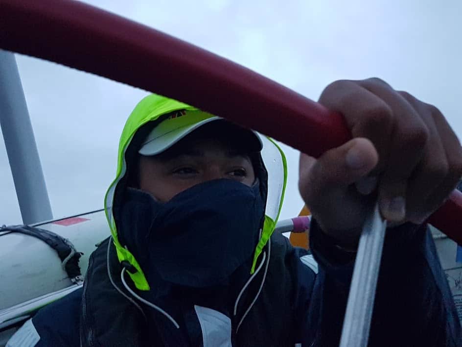A sailor wrapped up warm at the wheel of yacht Scaramouche
