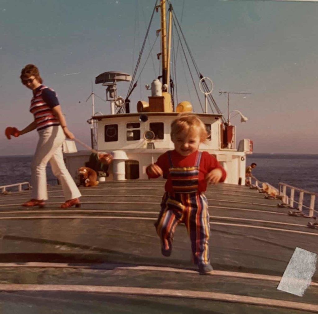 Minka Armitage running on the deck of a ship as a young child.