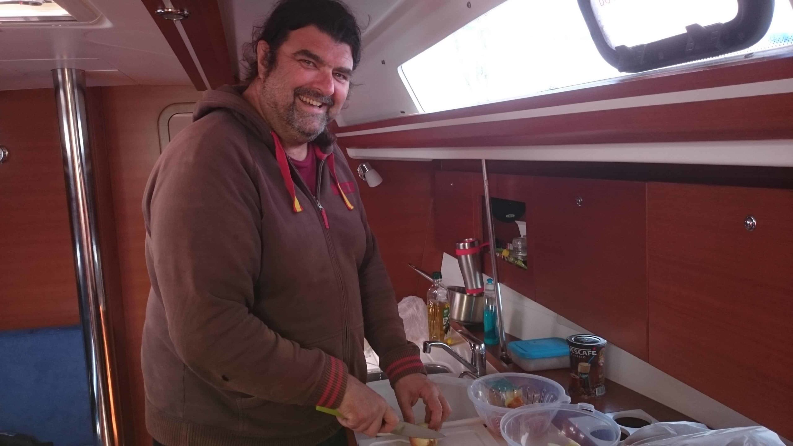 Professional yacht delivery skipper in the galley preparing lunch for the crew