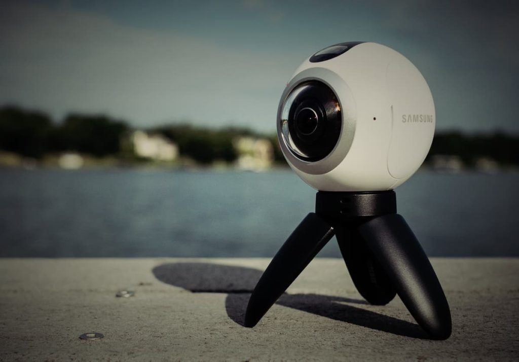 A samsung gear 360 camera close up with the sea in the background