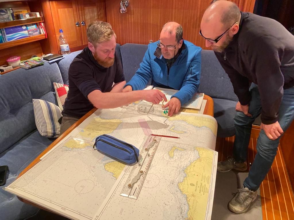 Working around the saloon table, doing some chart work and prep during the yacht delivery skippers development week.