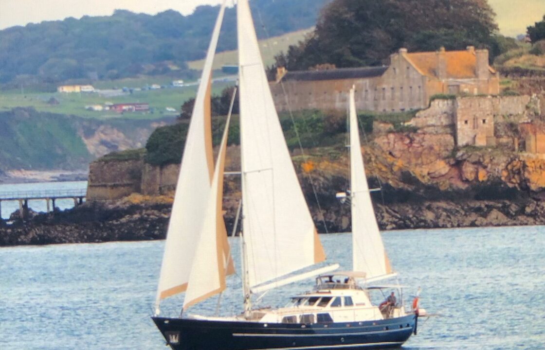 Cheoy Lee 19.5 metre yacht under full sail with Drakes Island behind setting off on the trans Atlantic delivery to the USA