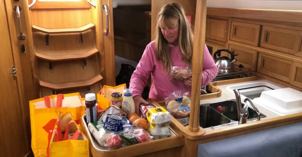 Yacht delivery skipper organising the food into the galley