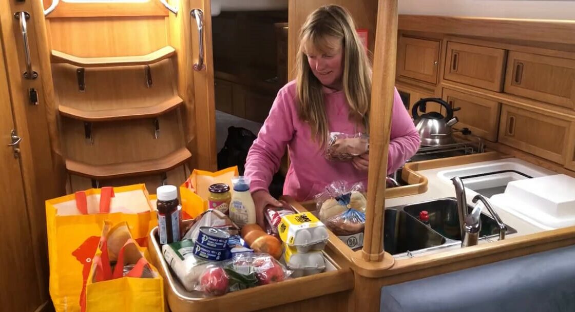 Yacht delivery skipper organising the food into the galley
